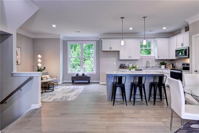 5311 Salzman St, Williamsburg, VA 23188 - kitchen with stainless steel appliances, baseboards, a breakfast bar area, white cabinetry, and healthy amount of natural light