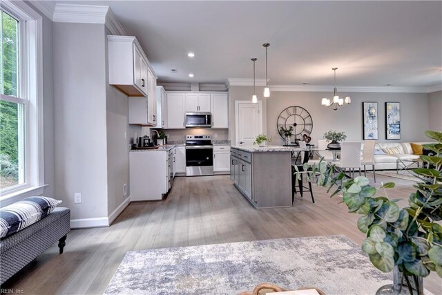 5311 Salzman St, Williamsburg, VA 23188 - kitchen featuring stainless steel appliances, plenty of natural light, white cabinetry, a chandelier, and ornamental molding