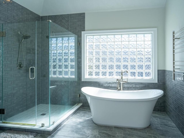 bathroom featuring a freestanding bath, tile walls, and a stall shower