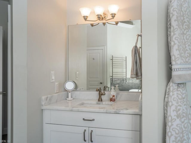 bathroom with a notable chandelier and vanity