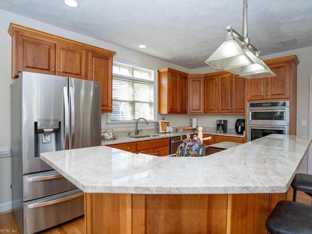 kitchen with brown cabinets, appliances with stainless steel finishes, and a sink