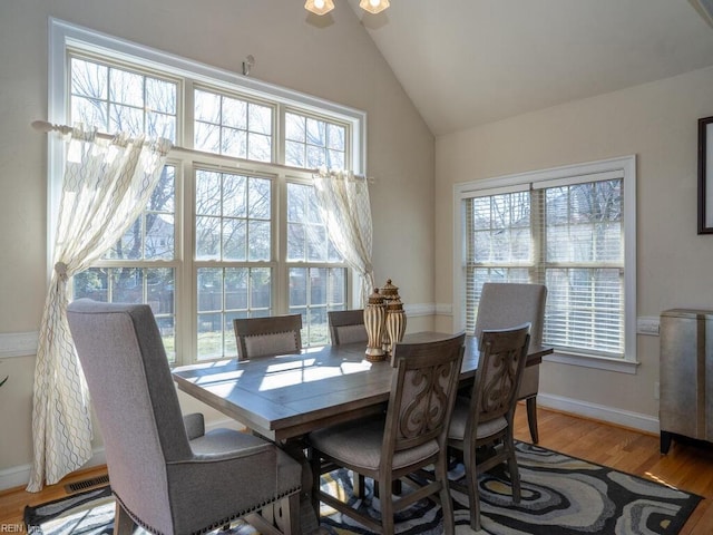 dining area with vaulted ceiling, plenty of natural light, baseboards, and wood finished floors