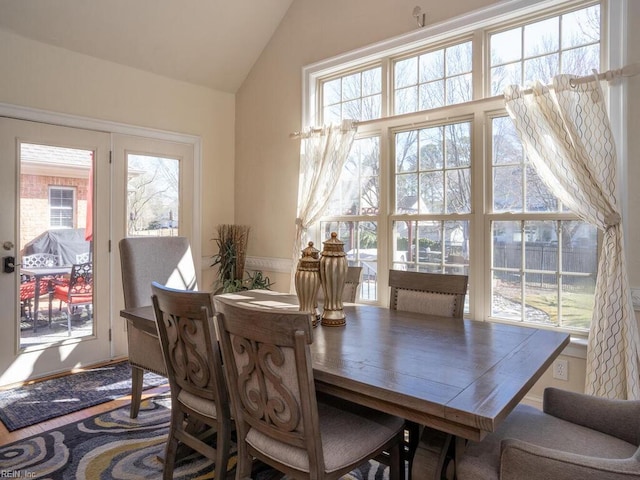 dining space with a wealth of natural light and vaulted ceiling