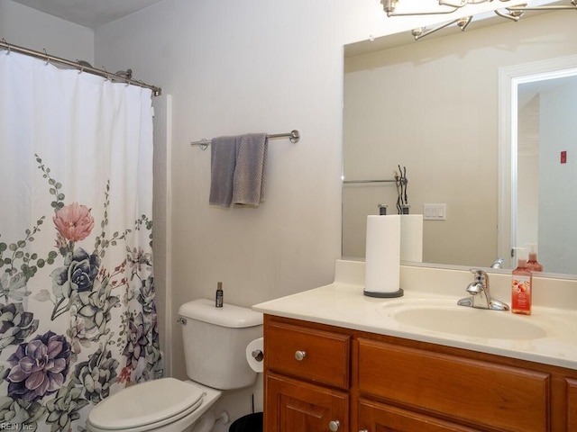 bathroom with curtained shower, toilet, and vanity