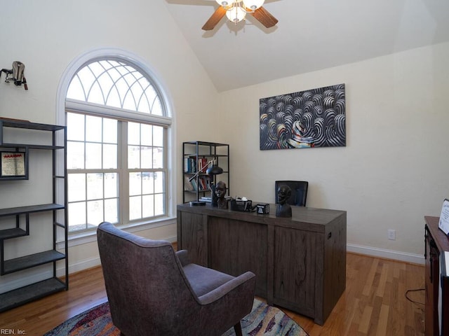 home office with baseboards, high vaulted ceiling, wood finished floors, and a ceiling fan