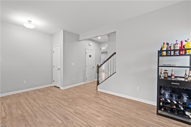 interior space featuring stairs, light wood-style floors, and baseboards