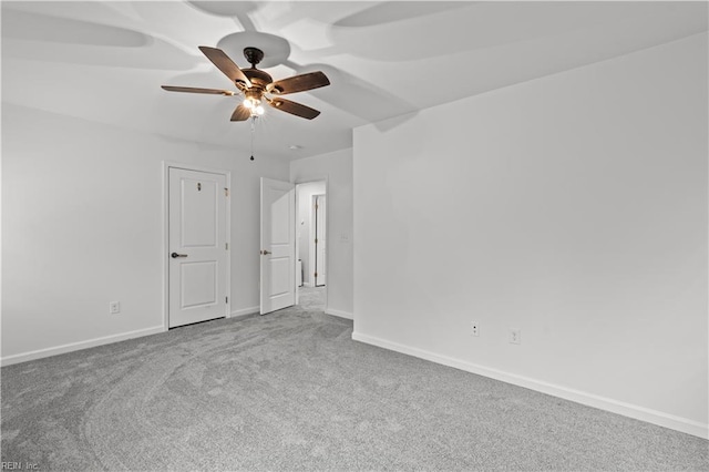 carpeted spare room with baseboards and ceiling fan