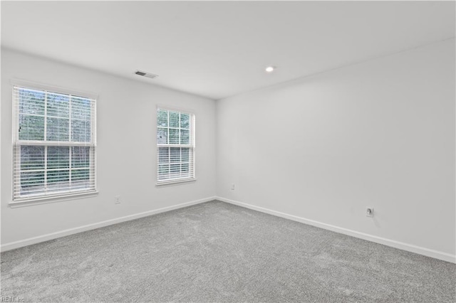 carpeted empty room with visible vents, recessed lighting, and baseboards