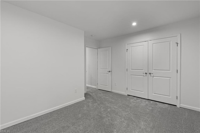 unfurnished bedroom featuring a closet, recessed lighting, baseboards, and carpet floors