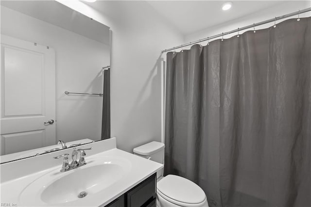 bathroom with vanity, a shower with shower curtain, and toilet