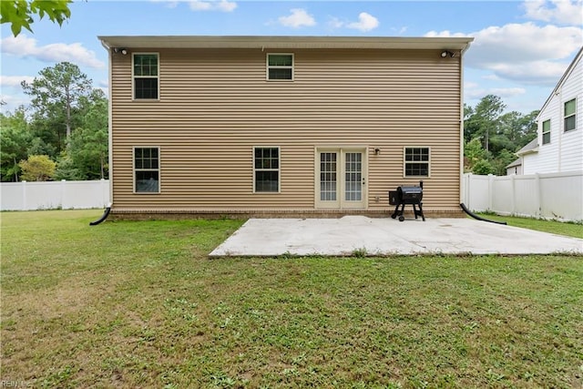 back of house featuring a yard, a fenced backyard, and a patio