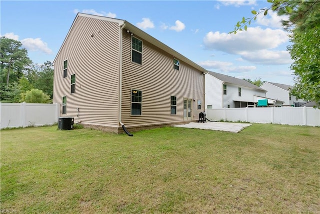 rear view of house featuring central AC unit, a patio, fence private yard, and a yard