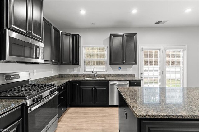 kitchen with a sink, dark cabinetry, visible vents, and stainless steel appliances
