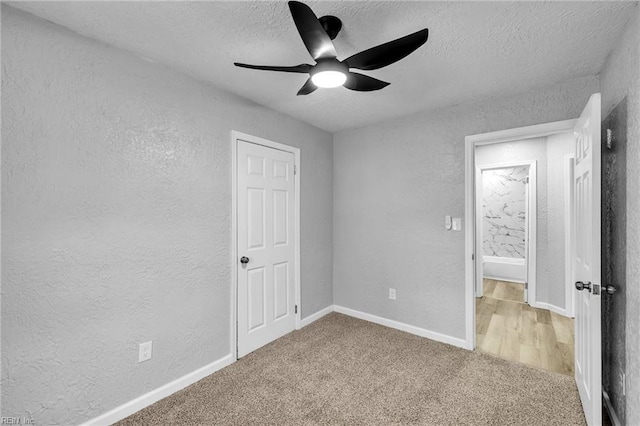 unfurnished bedroom with a textured ceiling, carpet, and a textured wall