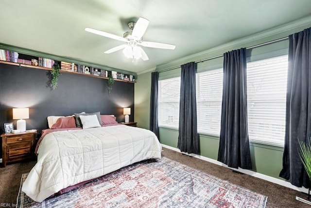 carpeted bedroom featuring visible vents, baseboards, a ceiling fan, and crown molding