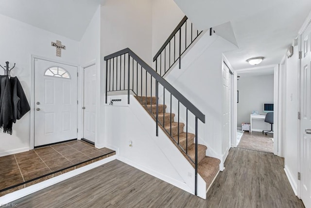 entrance foyer featuring baseboards, wood finished floors, and stairs