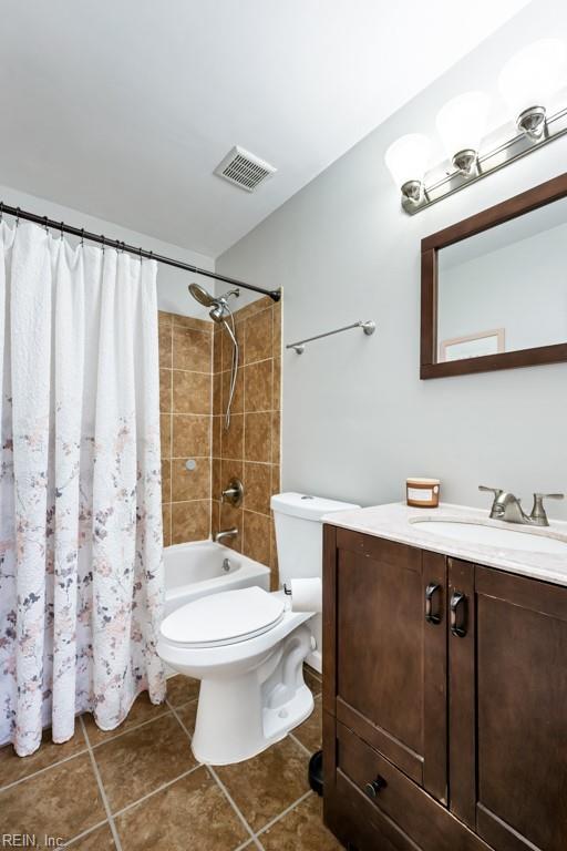 bathroom with visible vents, toilet, shower / bath combo, tile patterned floors, and vanity