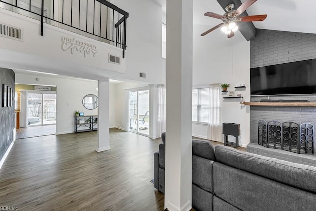 living room featuring visible vents, plenty of natural light, a ceiling fan, and wood finished floors