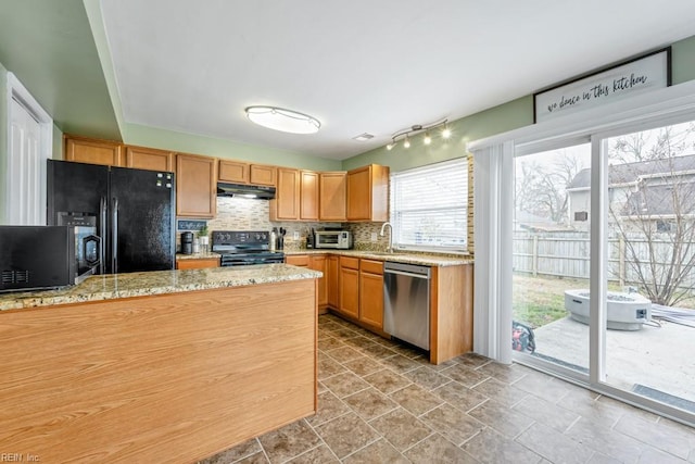 kitchen with a toaster, a sink, black appliances, under cabinet range hood, and backsplash