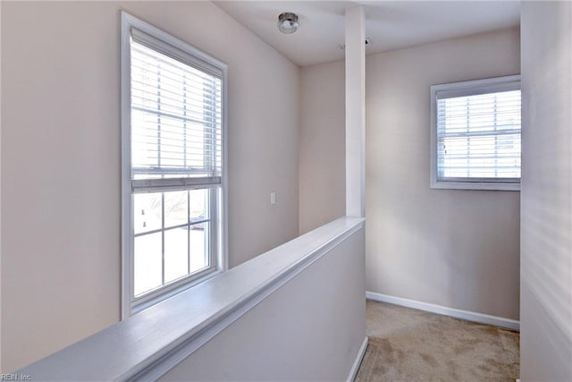 hallway featuring baseboards and carpet floors