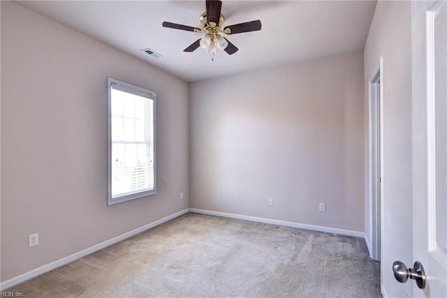 empty room with ceiling fan, baseboards, visible vents, and light carpet