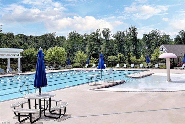 community pool with a patio area and fence