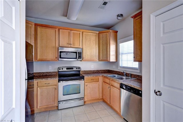 kitchen featuring dark countertops, visible vents, light tile patterned floors, stainless steel appliances, and a sink