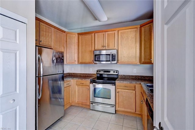 kitchen featuring light tile patterned flooring, appliances with stainless steel finishes, and a sink