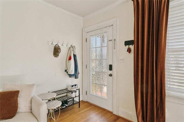 doorway with wood finished floors, a healthy amount of sunlight, and ornamental molding