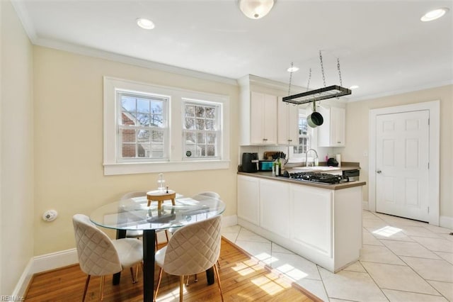 kitchen with white cabinets, baseboards, and ornamental molding