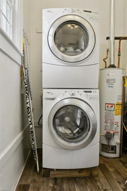 washroom featuring laundry area, gas water heater, wood finished floors, and stacked washer and dryer