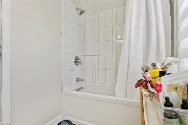 full bath featuring baseboards and shower / tub combo with curtain