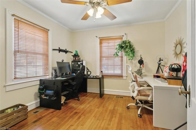 office area with visible vents, wood-type flooring, crown molding, baseboards, and ceiling fan