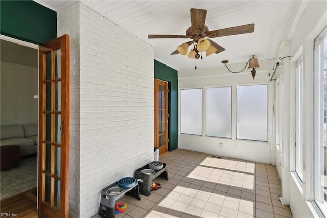 unfurnished sunroom featuring ceiling fan