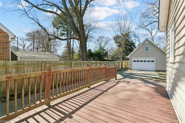 deck with a detached garage, an outdoor structure, and a fenced backyard