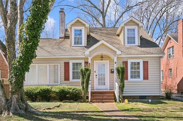 cape cod-style house featuring a front lawn, crawl space, roof with shingles, and a chimney