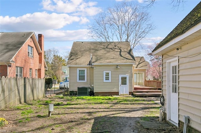 rear view of property featuring central air condition unit, a deck, and fence