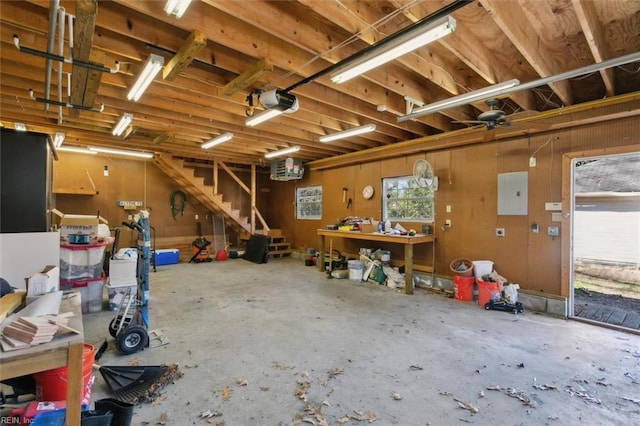 garage featuring a workshop area, electric panel, and a garage door opener