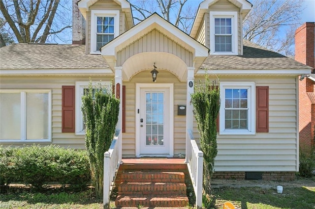 view of exterior entry with a shingled roof