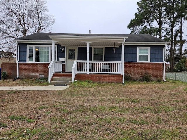 bungalow-style house featuring brick siding, fence, covered porch, and crawl space