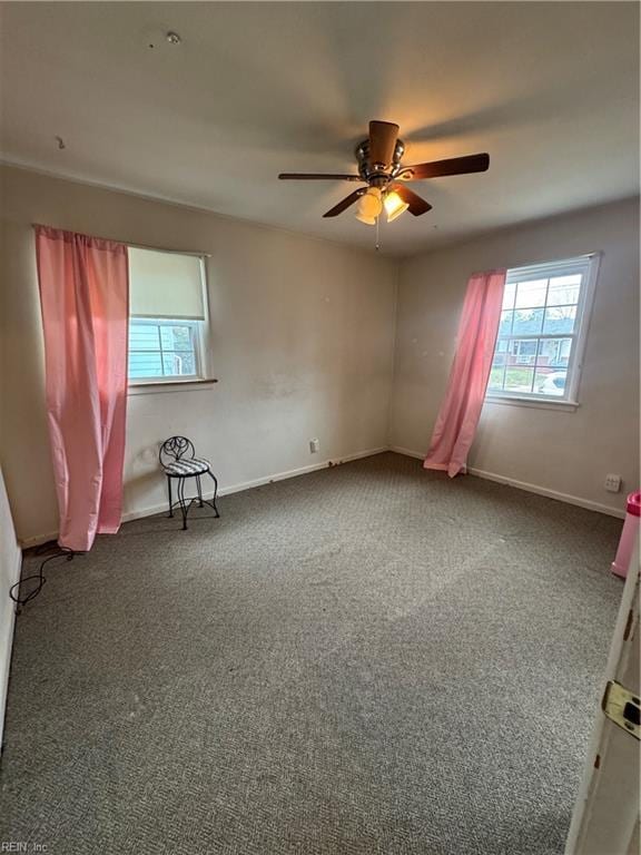 spare room featuring carpet flooring, baseboards, and a ceiling fan