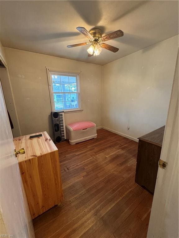 bedroom with a ceiling fan, baseboards, and wood-type flooring