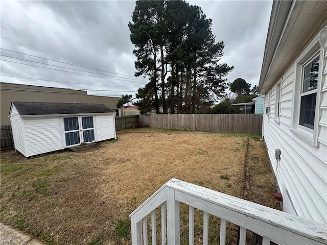 view of yard featuring an outbuilding, a storage shed, and a fenced backyard