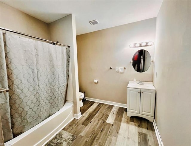 bathroom with visible vents, toilet, wood finished floors, baseboards, and vanity