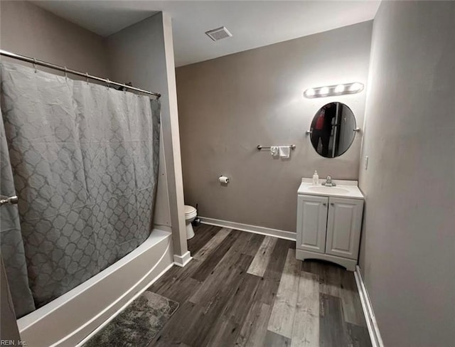 full bathroom with toilet, wood finished floors, visible vents, and baseboards