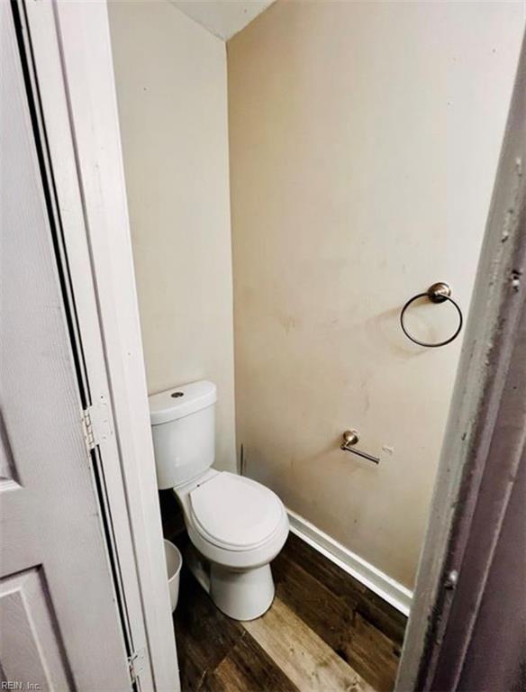 bathroom with toilet, wood finished floors, and baseboards