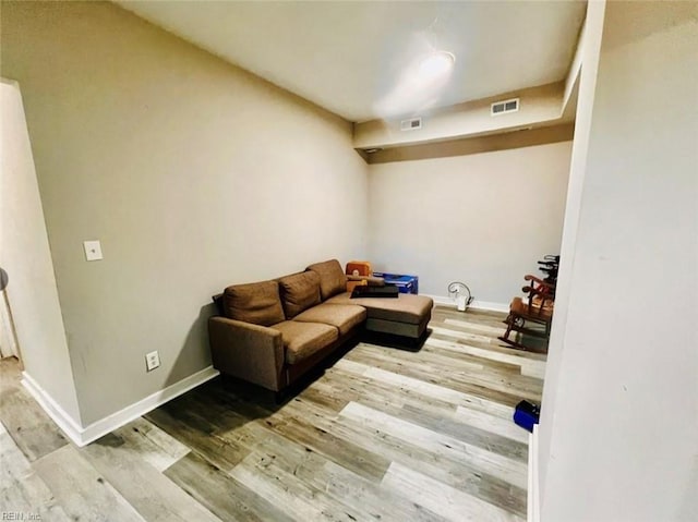 living area featuring visible vents, baseboards, and wood finished floors