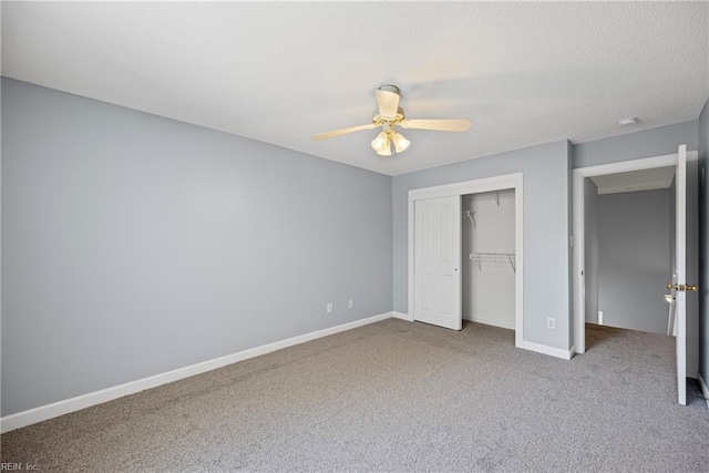 unfurnished bedroom featuring a ceiling fan, carpet, baseboards, a closet, and a textured ceiling