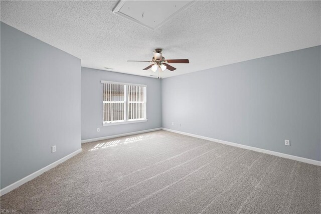 unfurnished room featuring baseboards, attic access, a ceiling fan, and carpet floors