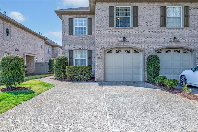 view of front of property with concrete driveway, a garage, and brick siding